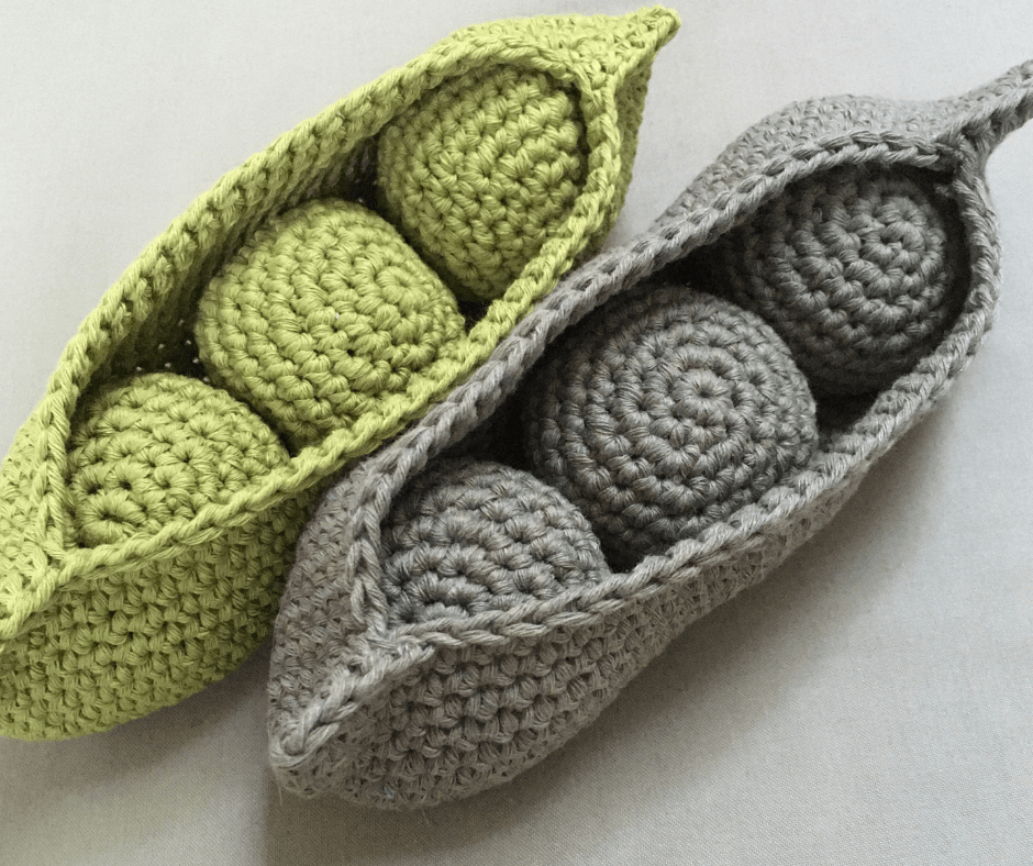 This a picture of two pods of peas containing three peas in each. One pod is coloured lime green the other a khaki colour. The two pods are crocheted and represent the 3 Ps of happiness