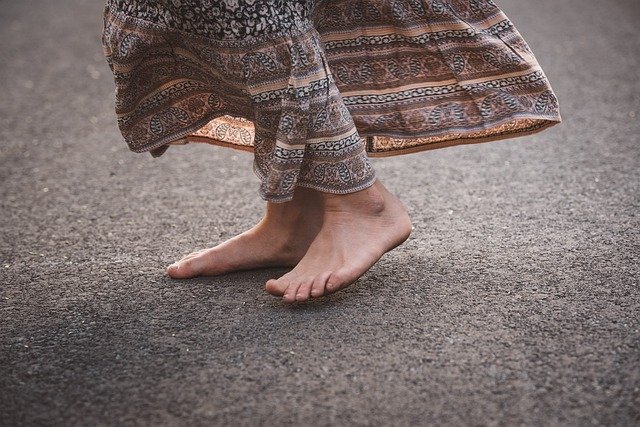 A picture of two feet in a floral dress dancing on a light brown carpet. You can only see up to the knees. It is about work life balance and about doing something fun.