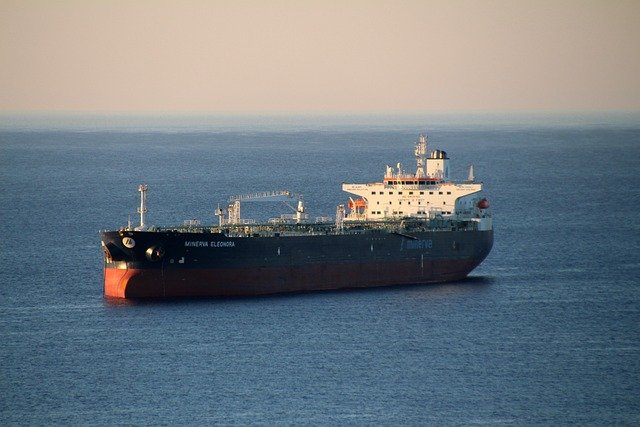 This is a picture of a tanker (ship) on the ocean. The ocean is blue witha white cloud and the tanker has a black hull and a white accommodation and steerage platform. Theb aim of the picture is to act as a metaphor for change needs to be slow, i.e slow down.