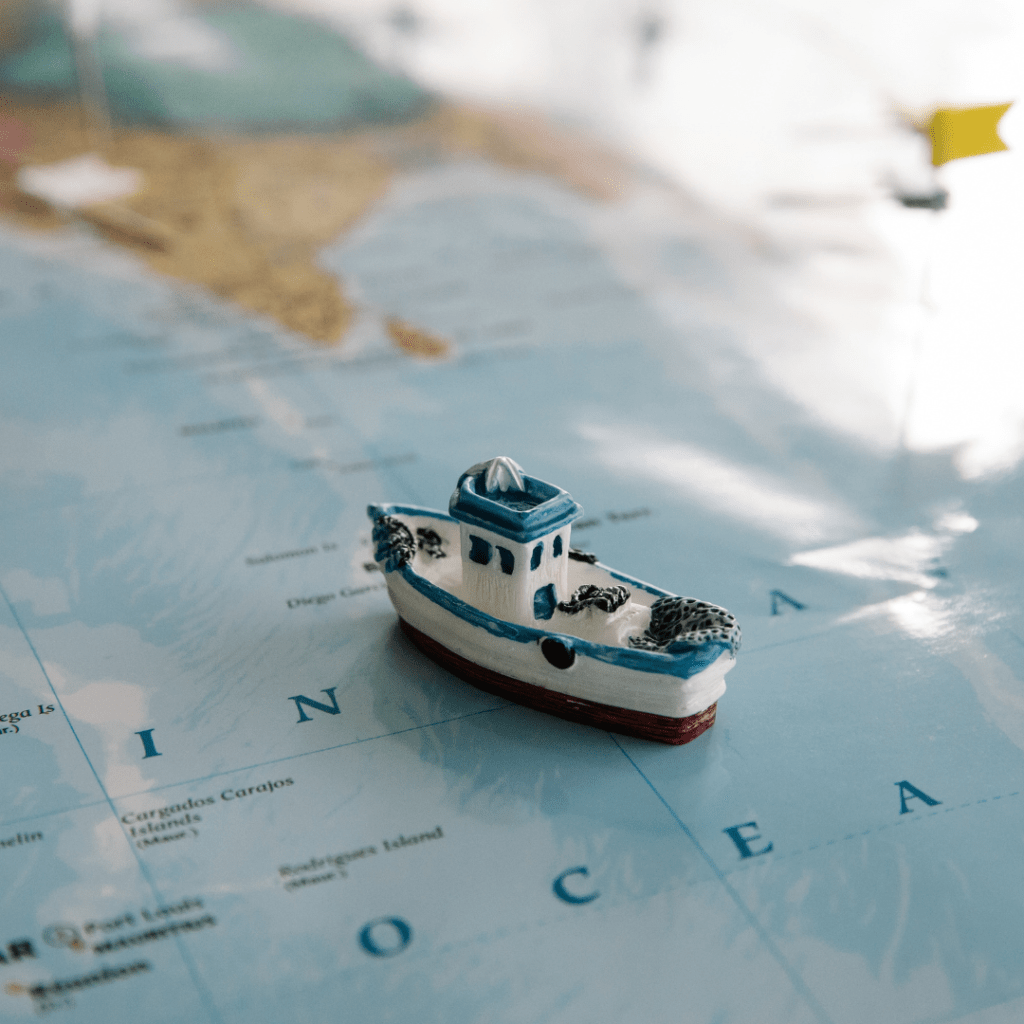 This is picture of a small toy boat (blue, white and brown in colour) on a world map. The aim of the picture is to infer that dealing with the imposter syndrome is a journey from the primitive mind to the intellectual mind.