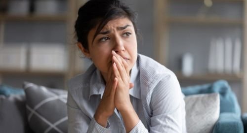 This is a mostly grey / blue picture of a young woman looking worried. Its purpose is to communicate anxiety and that Hypnotherapy Swindon can help.